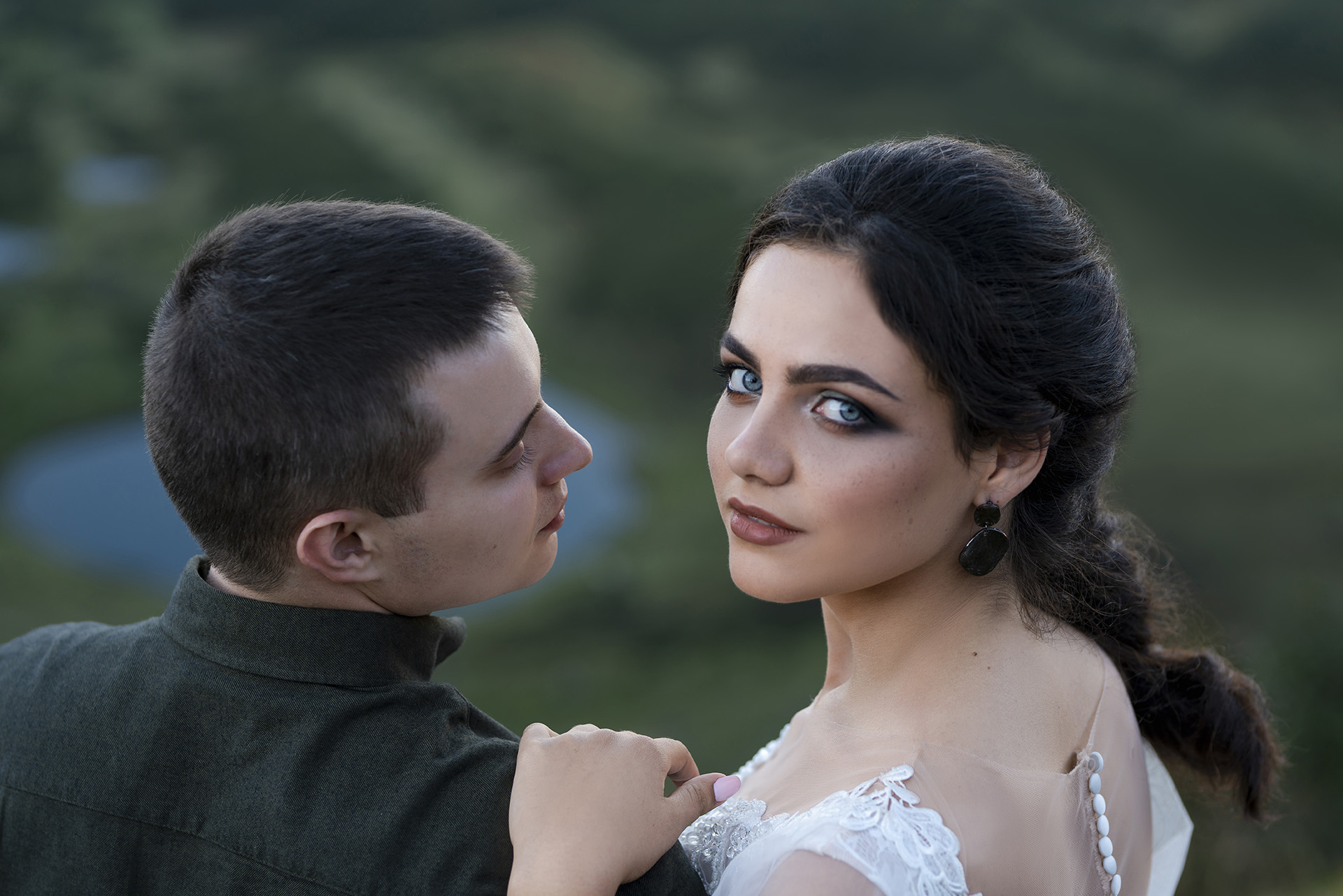 наречений і наречена обіймаються на тлі озера